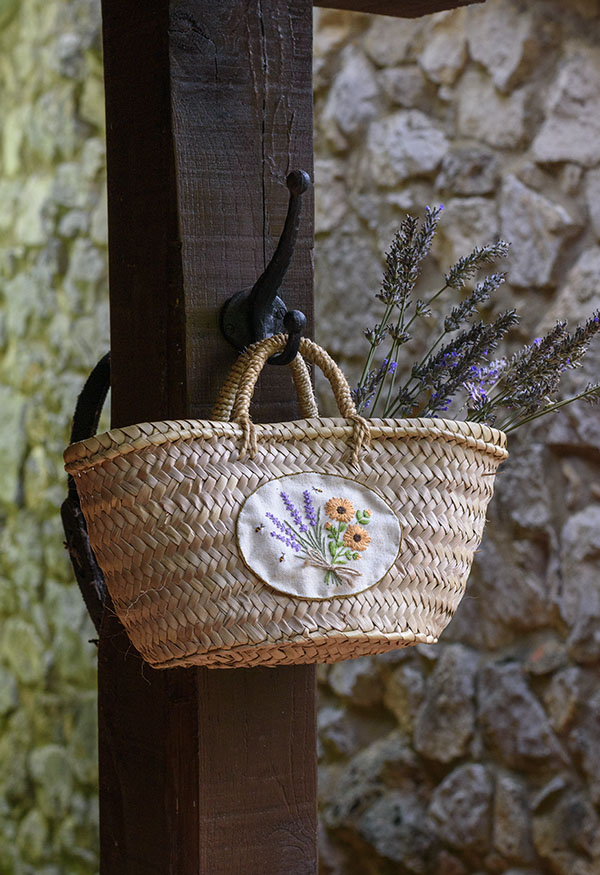 Capazo de palma personalizado con un parche de tela de lino bordado a mano con un ramillete de flores de lavanda y calendula por Arorua